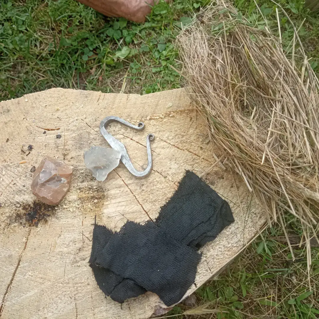 Acciarino medievale, pietra focaia e tela carbonizzata sull'erba