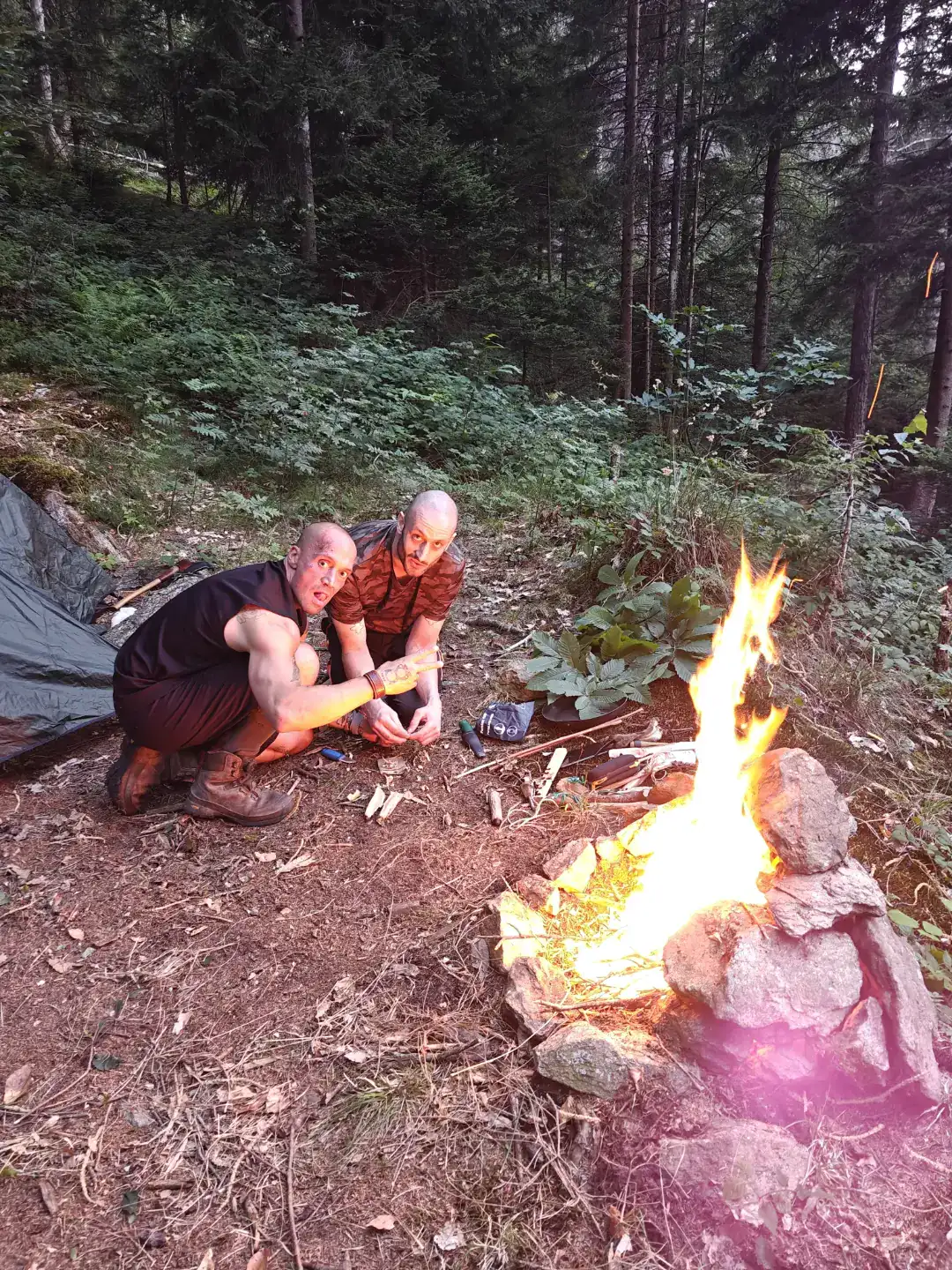 Due allievi accanto al fuoco al tramonto nel bosco